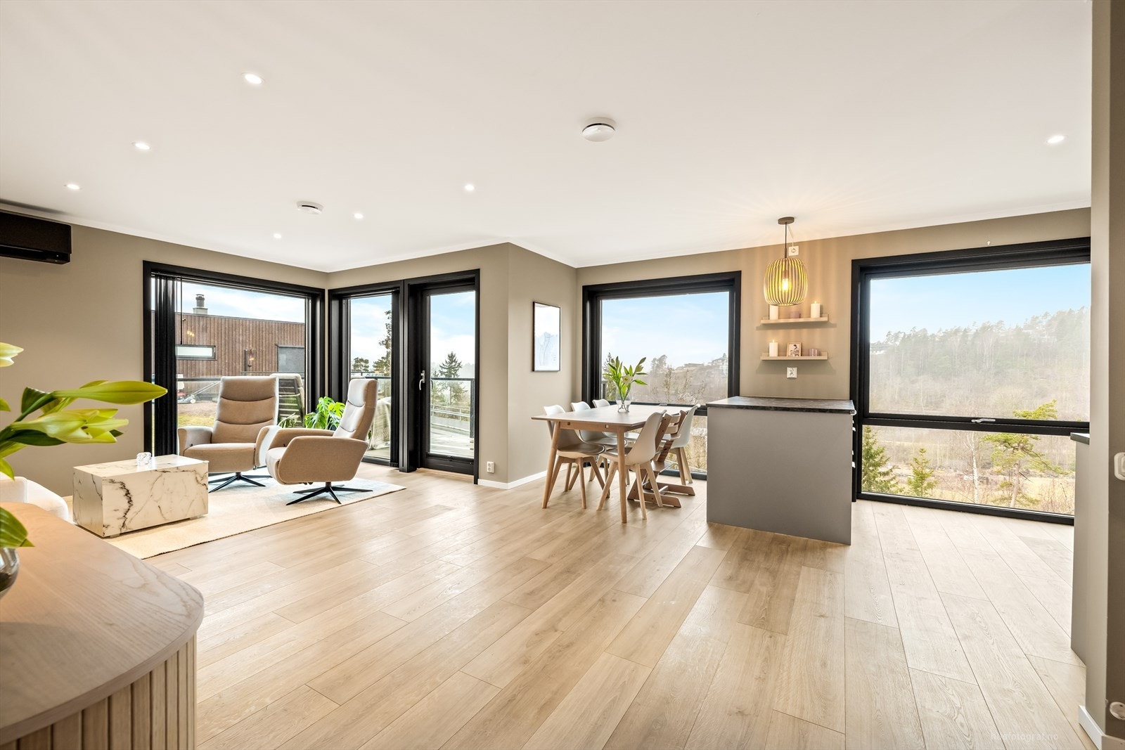 Lys og lekker stue i 1.etasje med 1-stavs laminat på gulv og slette vegger malt i en trendy fargetone, som skaper en lun stemning til rommet. Galleribilde