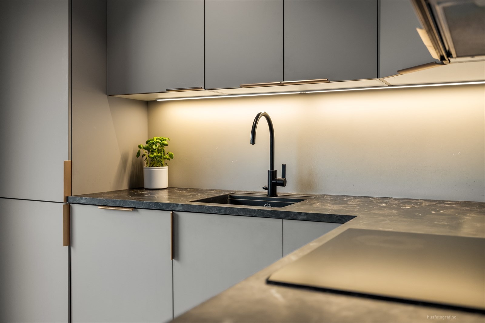 Kjøkkenet har et moderne preg og har slett vegg over kjøkkenbenken. Galleribilde