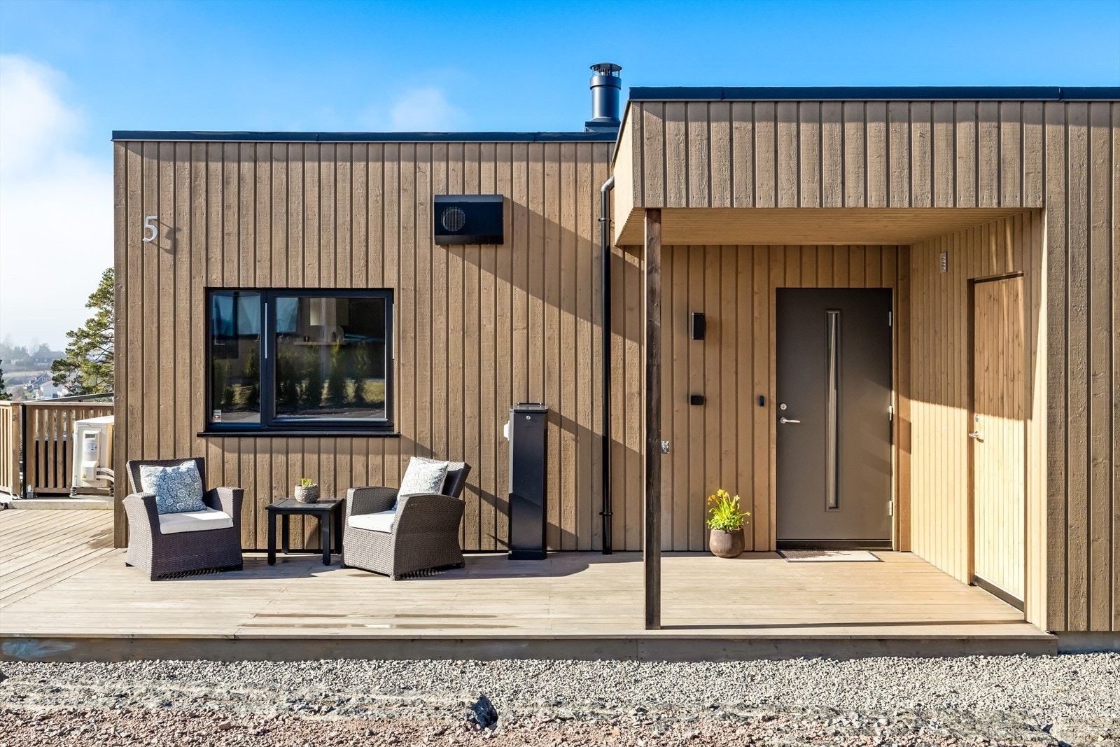 Det er uteplass også på fremsiden av boligen, med tilhørende utebod. Galleribilde