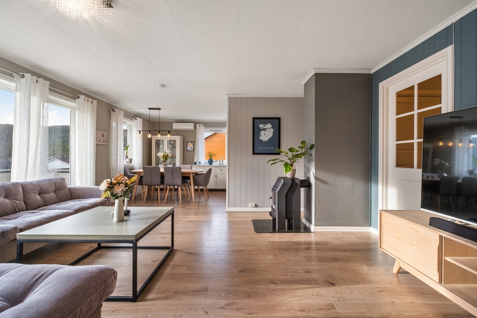 Oppholdsrommet er romslig, og vinduer langs flere vegger gir godt med dagslys inn i rommet. Galleribilde