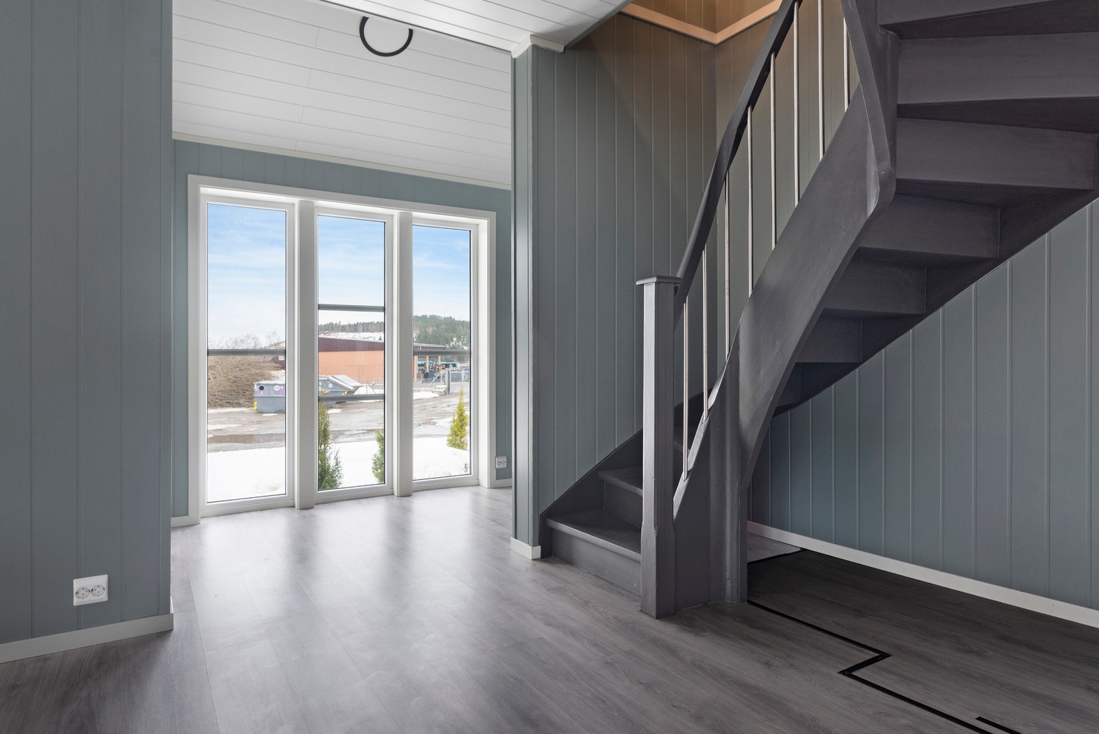 Lyst rom med store vinduer og trapp til andre etasje. Galleribilde