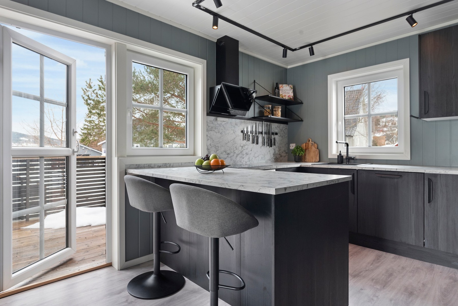 Kjøkkenet har moderne innredning, kjøkkenøy med sitteplasser og utgang til veranda. Store vinduer gir godt med naturlig lys. Galleribilde