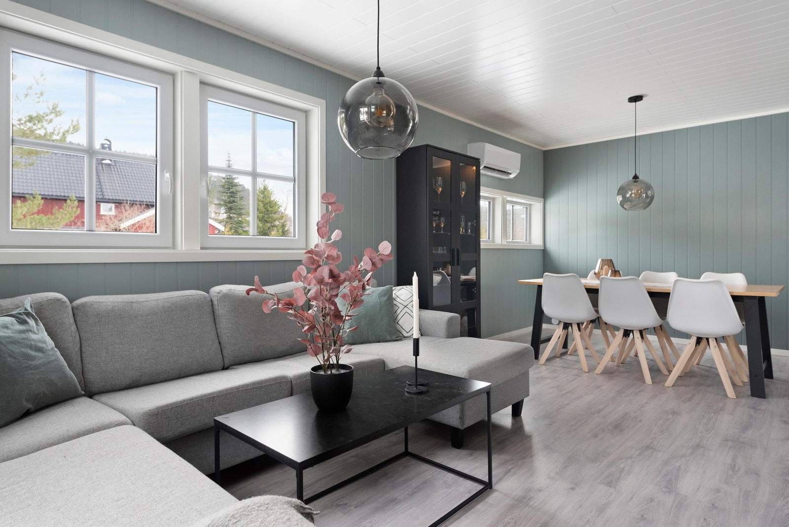 Lyst og moderne oppholdsrom med store vinduer og plass til både sofagruppe og spisebord. Galleribilde