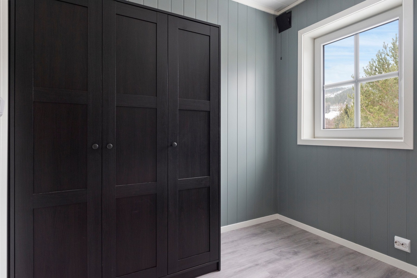 Rommet har et vindu med utsikt, lyse vegger og gulv, samt et garderobeskap. Galleribilde