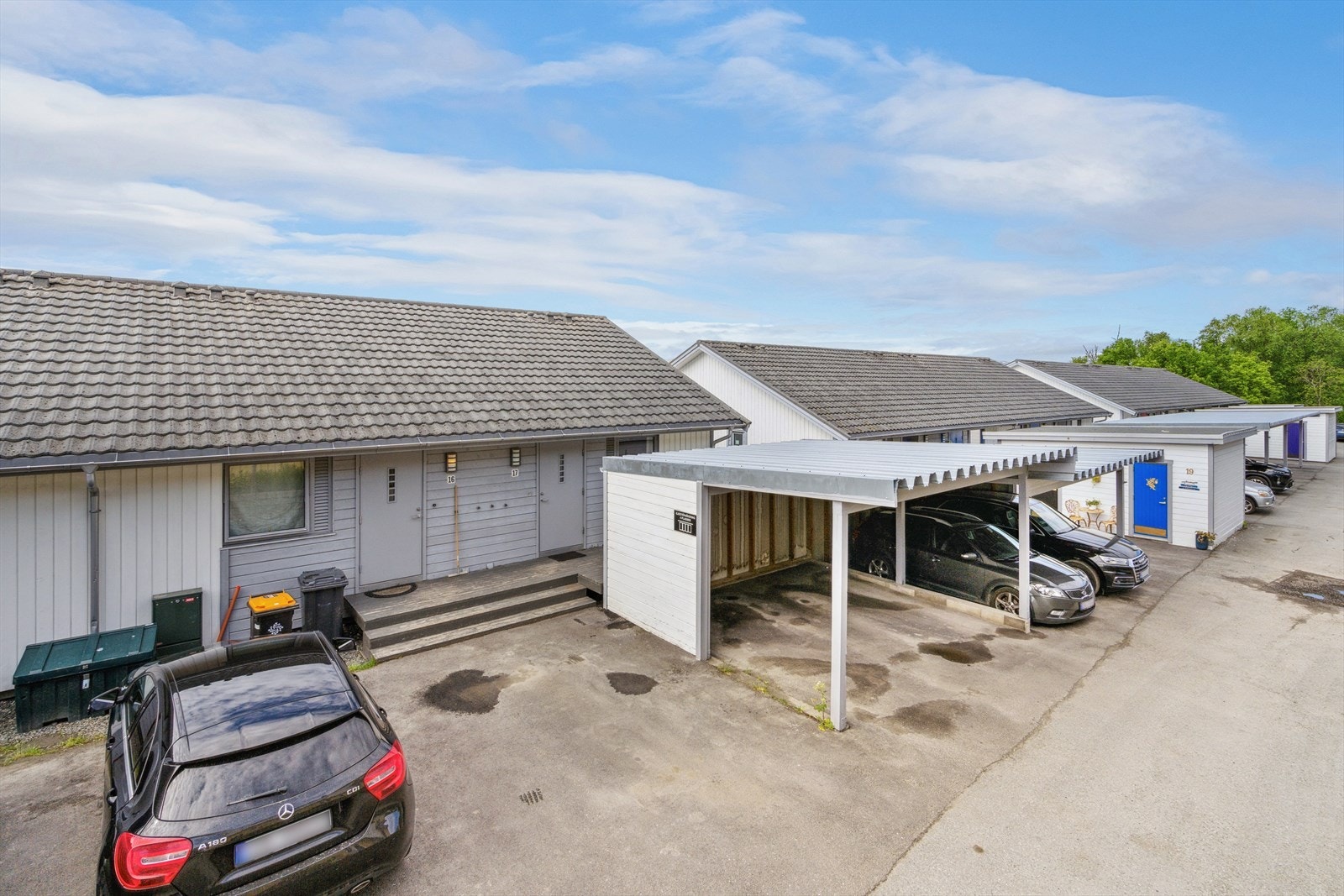 Asfalterte adkomstarealer foran inngangspartiet og området hvor boligens egen carport er plassert. Galleribilde