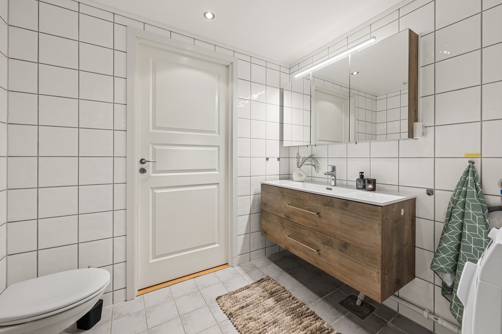 Baderomsinnredning med heldekkende servant og god oppbevaringsplass i skuffer og speilskap. Galleribilde