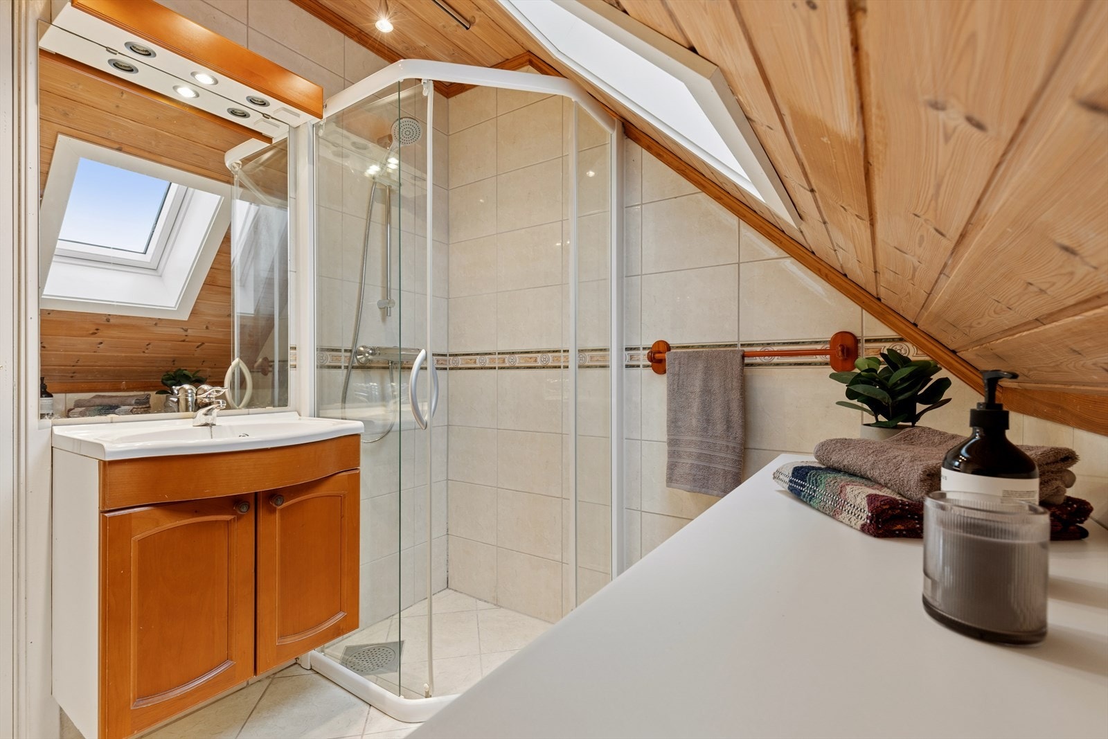 Badet i etasjen ble pusset opp i 2000 og har fliser på både gulv og vegger, samt dusjhjørne og servant med skap. Galleribilde