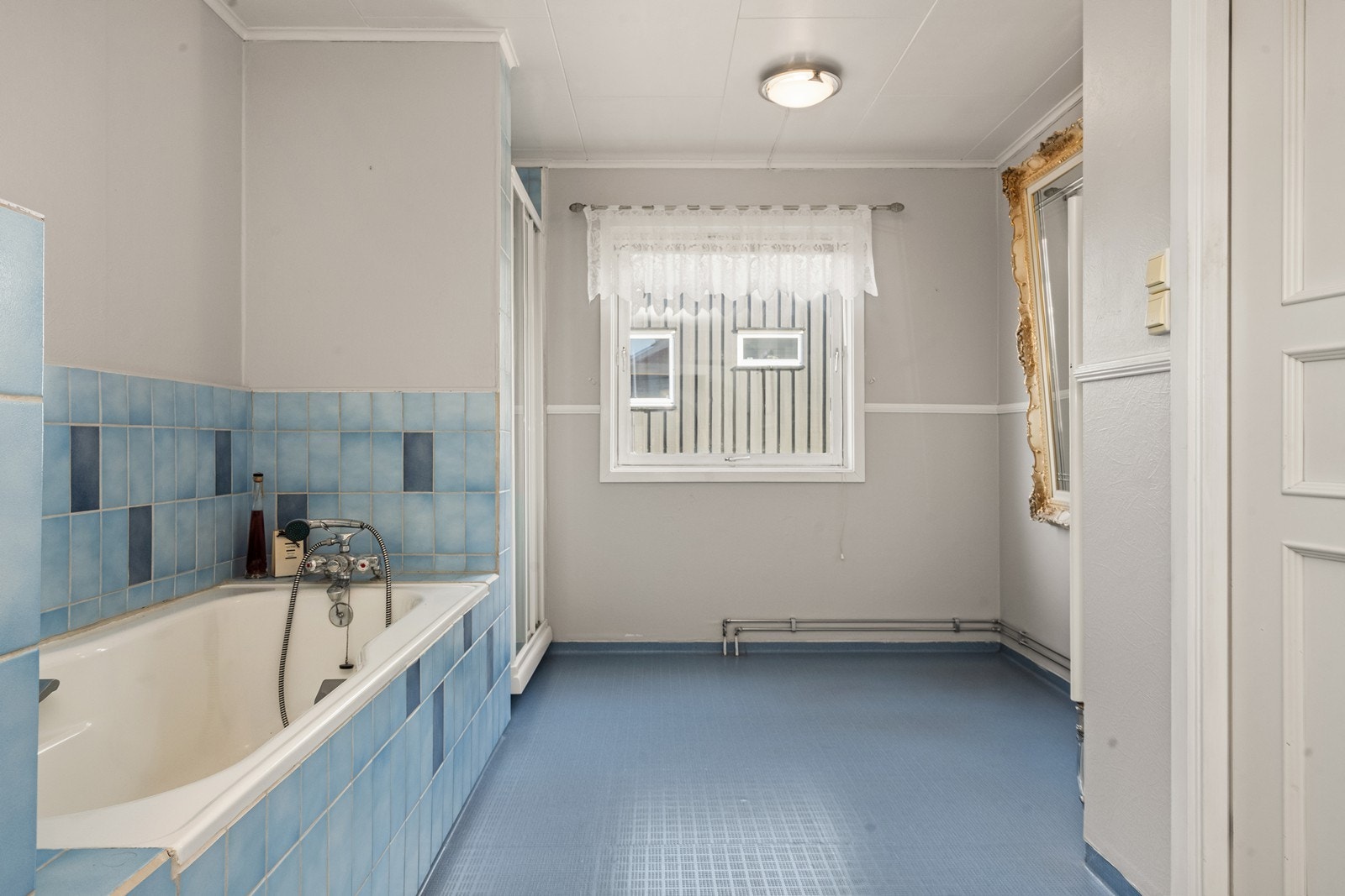 Badet er innredet med baderomsinnredning med to nedfelte servanter, speil, belysning og tilhørende veggskap, dusjkabinett samt badekar og toalett. Galleribilde