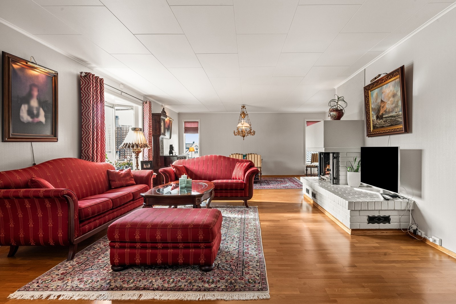 Boligen har en romslig stue med en peis som kan varme opp på kjølige dager. Galleribilde