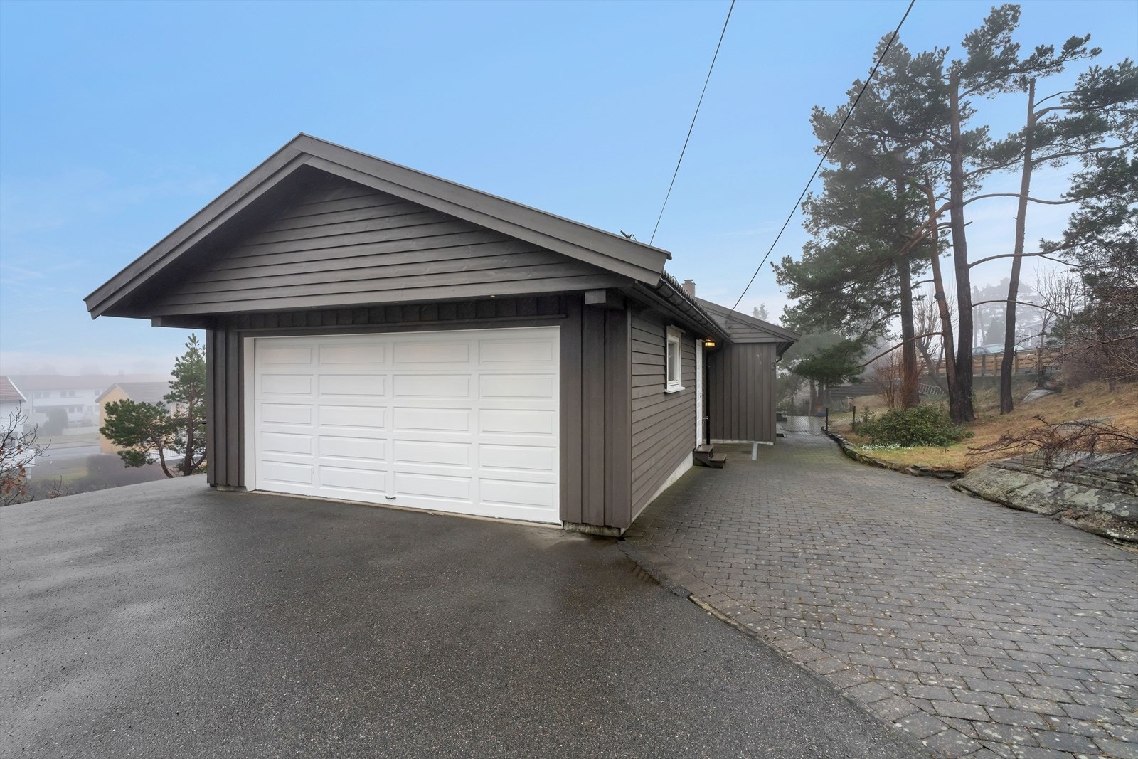 Ved adkomst til boligen blir du møtt av en nyere, dobbel garasje. Garasjen har elektrisk portåpner og har ellers godt med oppbevaringsmuligheter. Galleribilde
