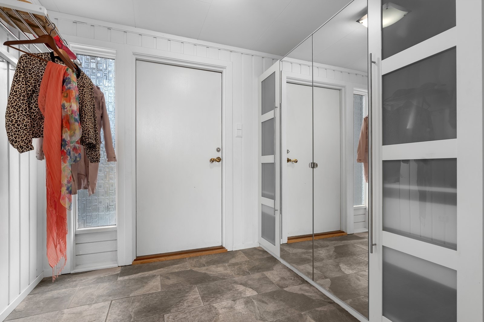 Velkommen inn! I yttergangen er det lagt keramiske fliser og det er montert garderobeskap med rikelig oppbevaringsplass. Galleribilde