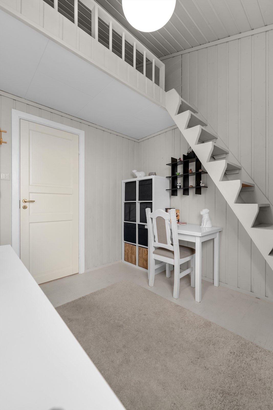 Rommet har også en trapp som leder opp til en koselig hems, noe som gir ekstra oppbevaringsplass eller en fin liten plass for avslapning. Galleribilde