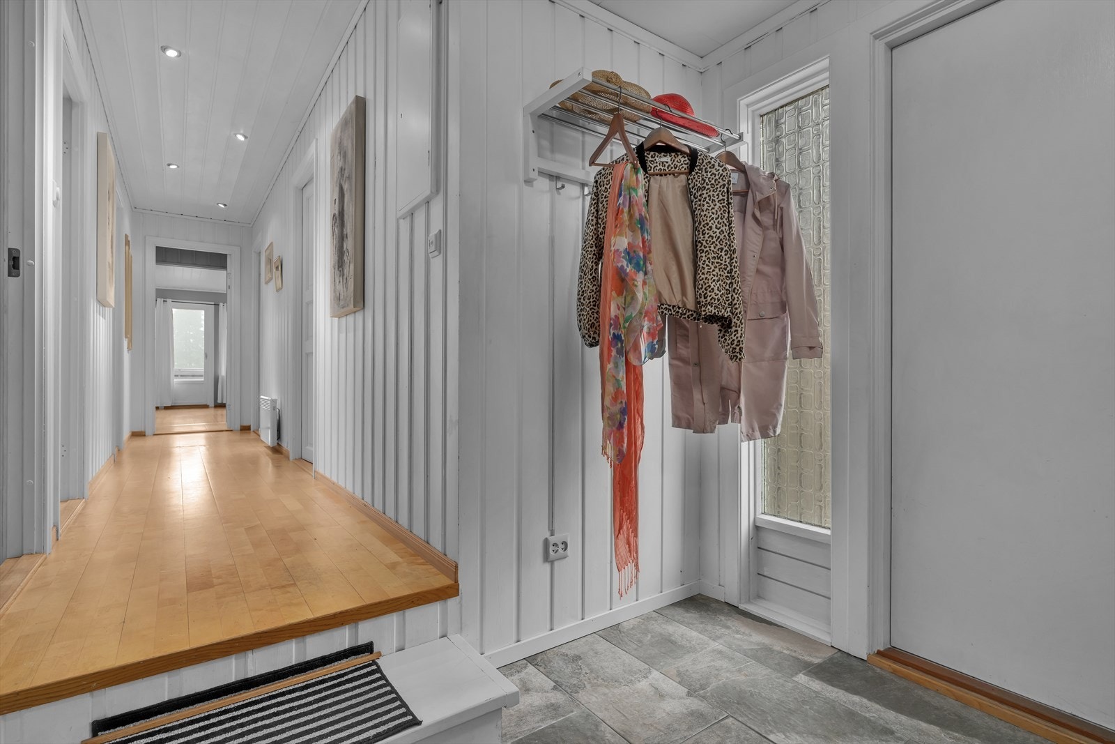 Fra gangen beveger du deg videre inn i en mellomgang med moderne spotter i taket. Galleribilde