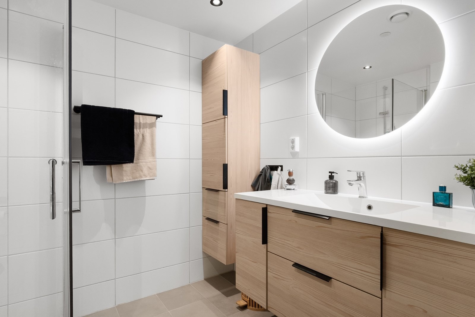 Badet er stilrent og moderne med flislagte gulv og vegger, samt malte himlingsplater med downlights. Galleribilde