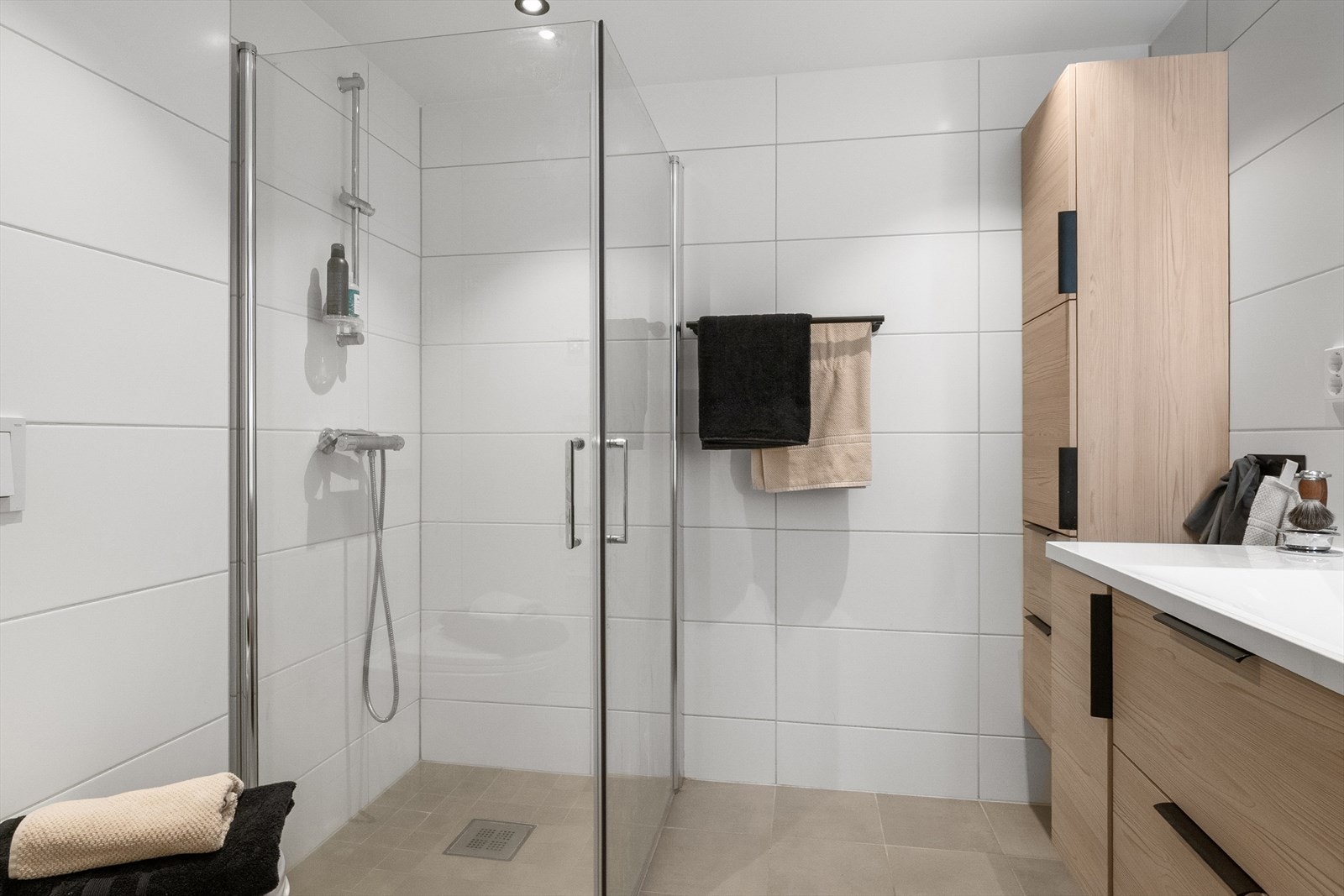 Videre er det veggmontert toalett med innebygget sisterne, samt en vegghengt dusjløsning med skjermdører i herdet glass. Galleribilde