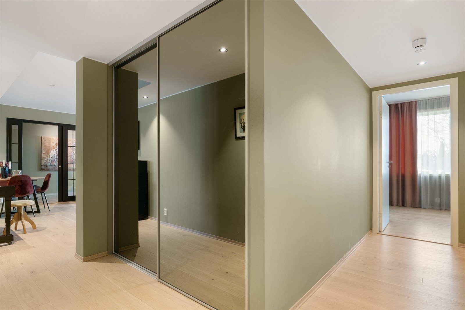 Entréen er lys og praktisk utformet, med god plass til oppbevaring av sko og yttertøy i en romslig skyvedørsgarderobe med speilfronter. Galleribilde