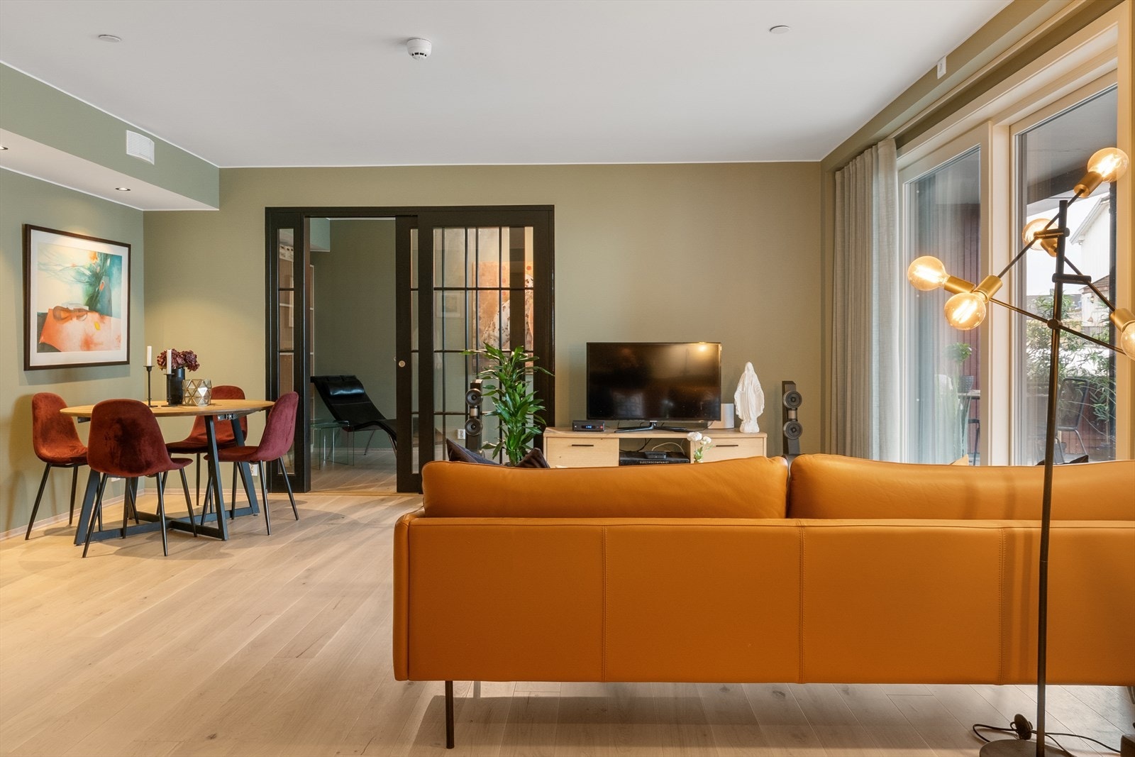 Store vindusflater slipper inn rikelig med naturlig lys og gir rommet en luftig og innbydende følelse. Galleribilde