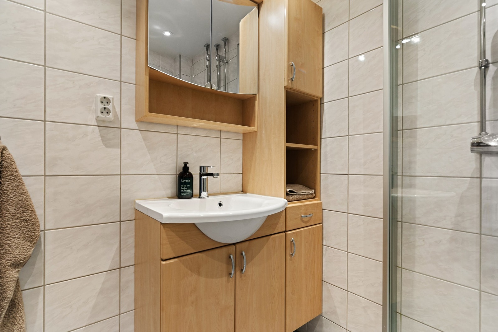 På badet er det baderomsinnredning med servant, speilskap med belysning, dusj med svingbare glassdører og opplegg til vaskemaskin Galleribilde