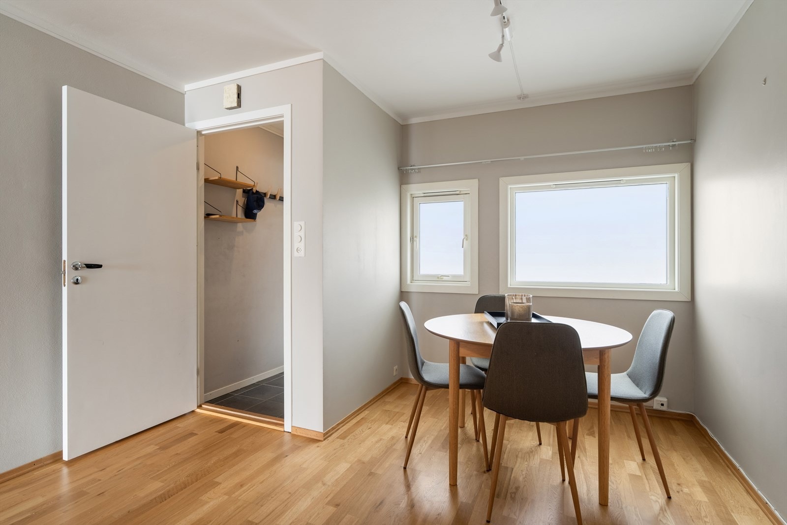 Parkettgulv gir en elegant finish til spiseområdet, med naturlig lys fra vinduene. Galleribilde