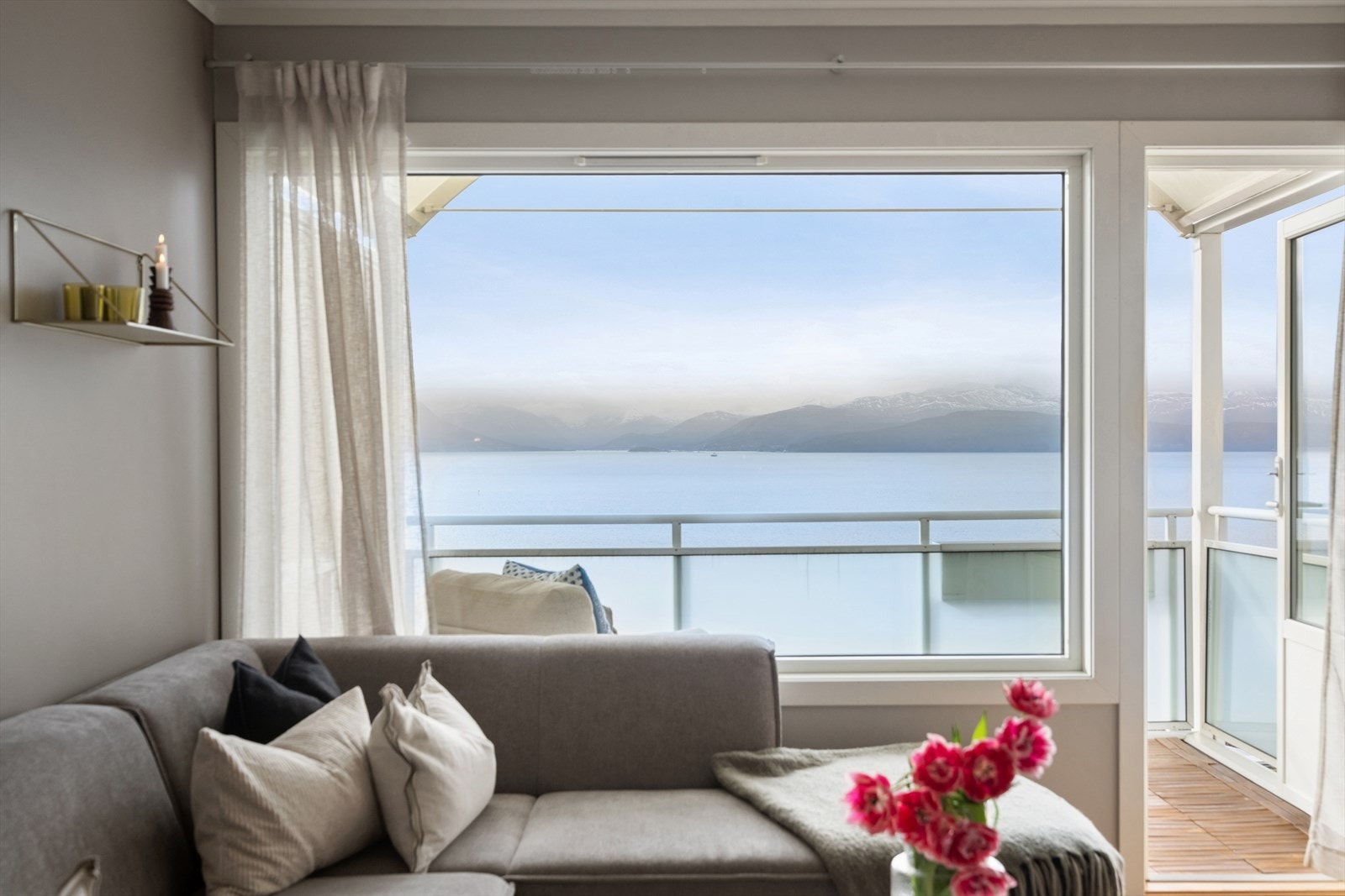 Store vindusflater i stuen gir utsikt mot fjorden og god tilgang til naturlig lys. Galleribilde