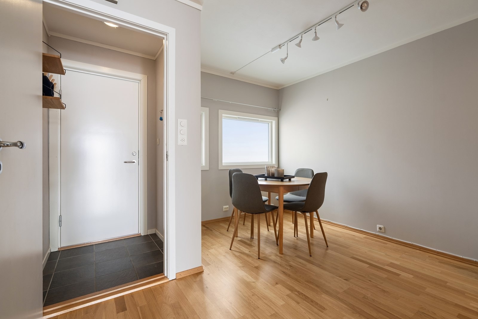 Parkettgulv og malte, slette vegger gir et rent inntrykk i stue og spiseområde. Galleribilde