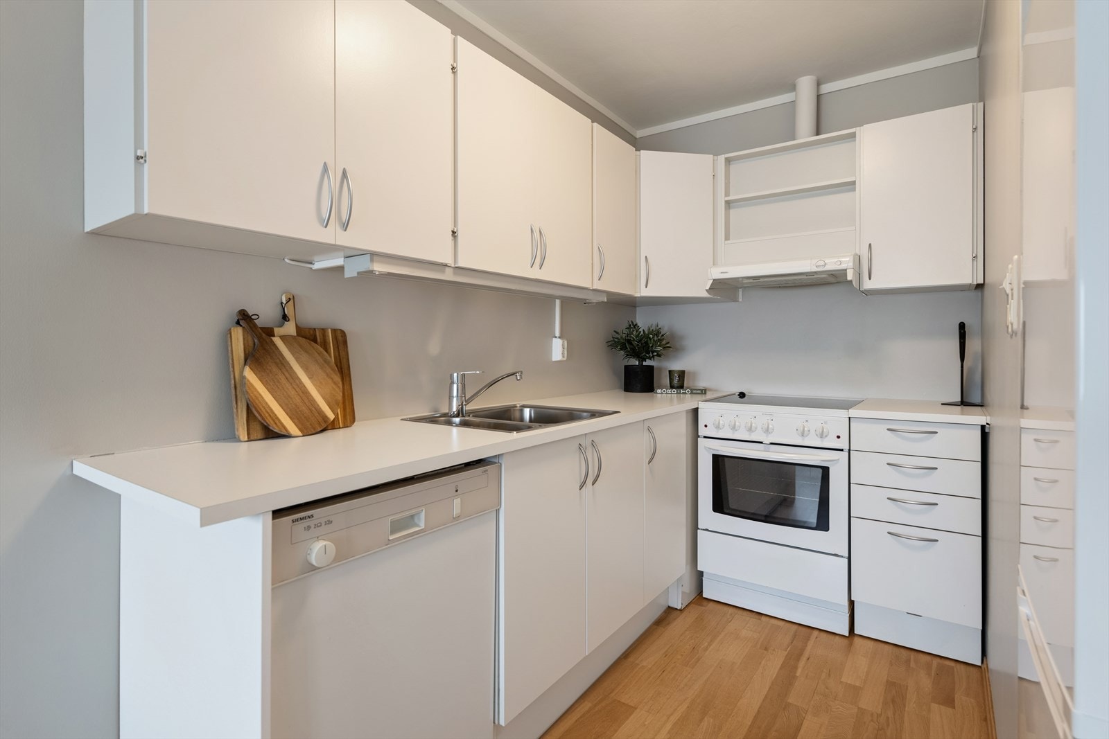 Kjøkkenet har parkettgulv og skap med glatte fronter, samt benkeplate i laminat. Det er avtrekk via felles avtrekksanlegg. Galleribilde