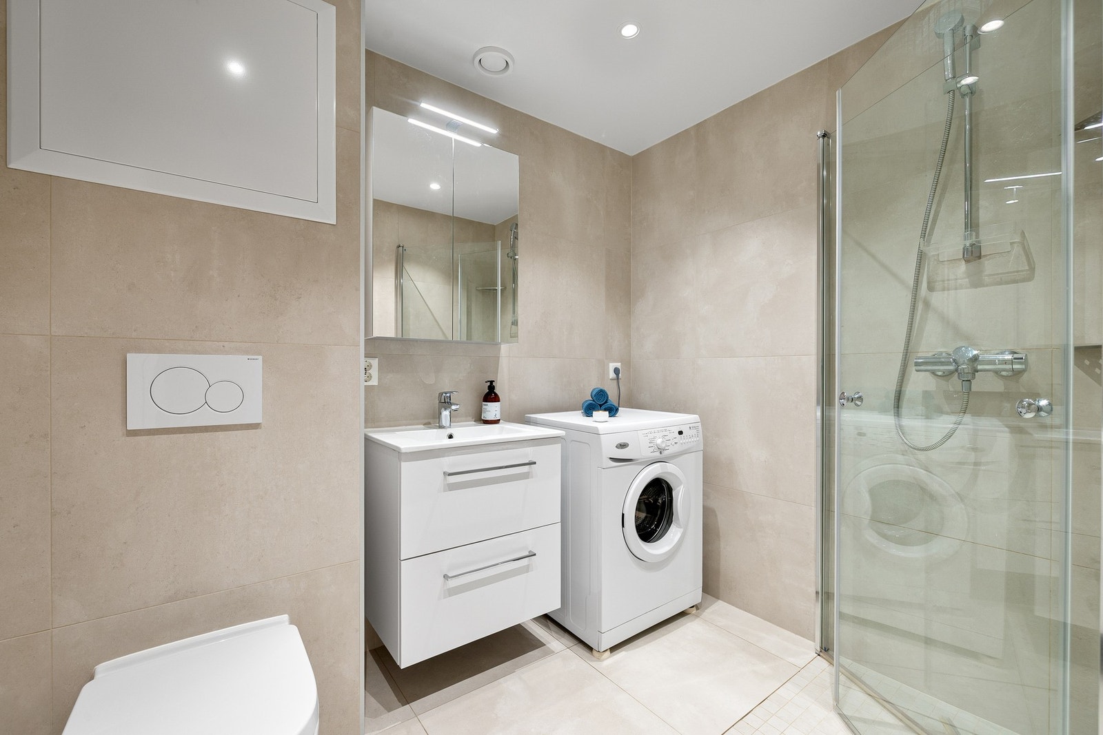 Badet er praktisk utnyttet med dusj, servant og opplegg for vaskemaskin Galleribilde