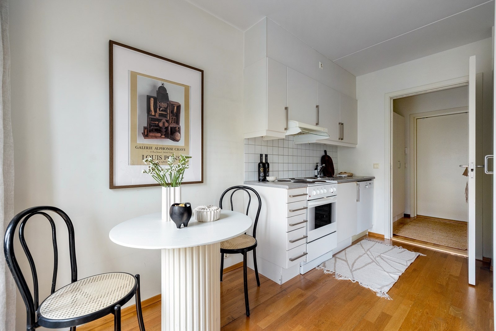 Kjøkkenet har en praktisk utforming med glatte, folierte fronter og fliser over laminatbenken. Galleribilde