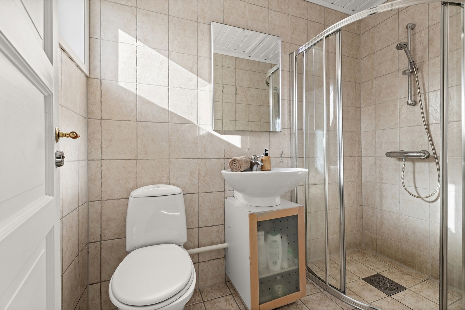Badet fra 2000 er innredet med dusjhjørne, servantskål på underskap og gulvstående toalett. Galleribilde