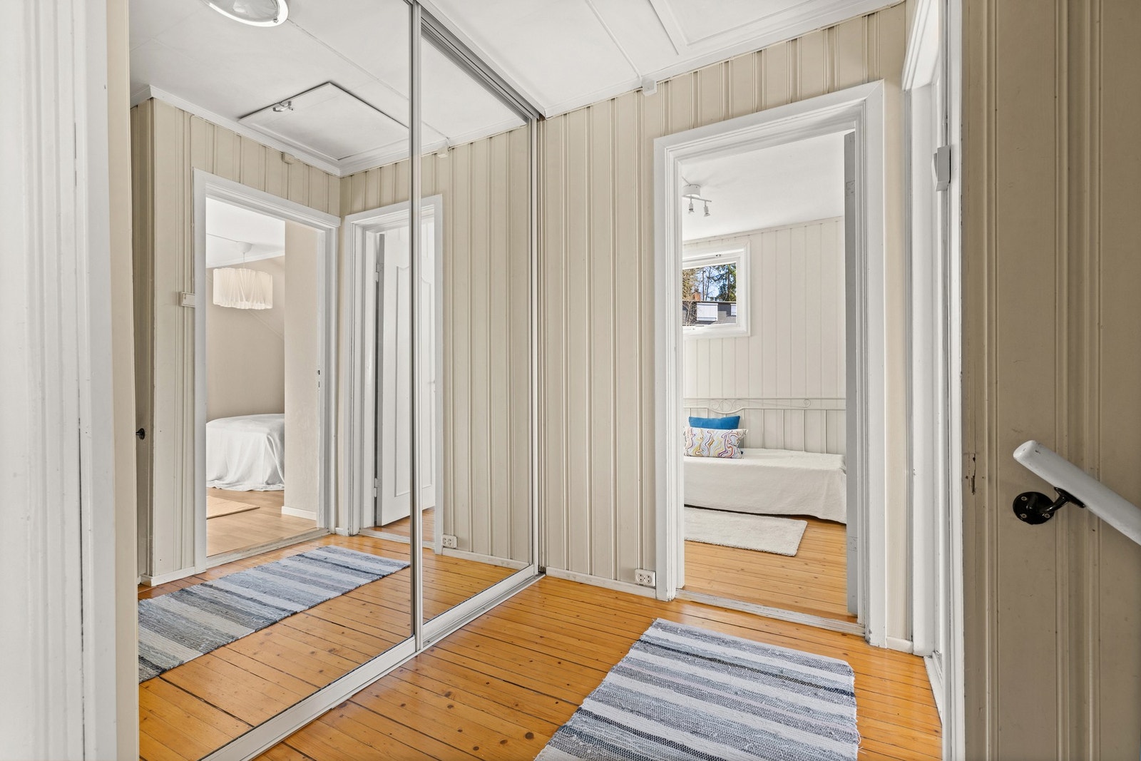 Gang/trapperom oppe i soveromsetasjen er innredet med en stor skyvedørsgarderobe med speilfronter. Galleribilde