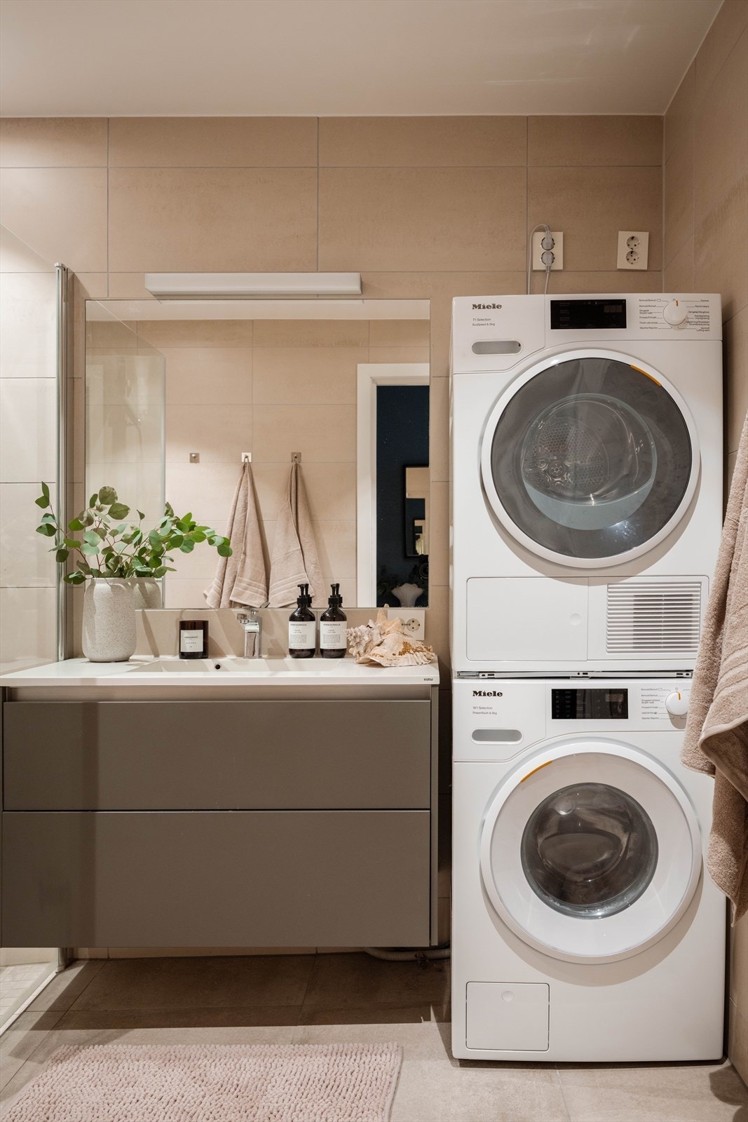 Over servant er det speil med tilhørende lysarmatur som gir gode lysforhold. Badet er videre utstyrt med veggmontert toalett og et romslig dusjhjørne med svingdører. Dusjsonen har sluk i gulv, regnfallsdusj og termostatstyrt blandebatteri for økt komfort. Galleribilde