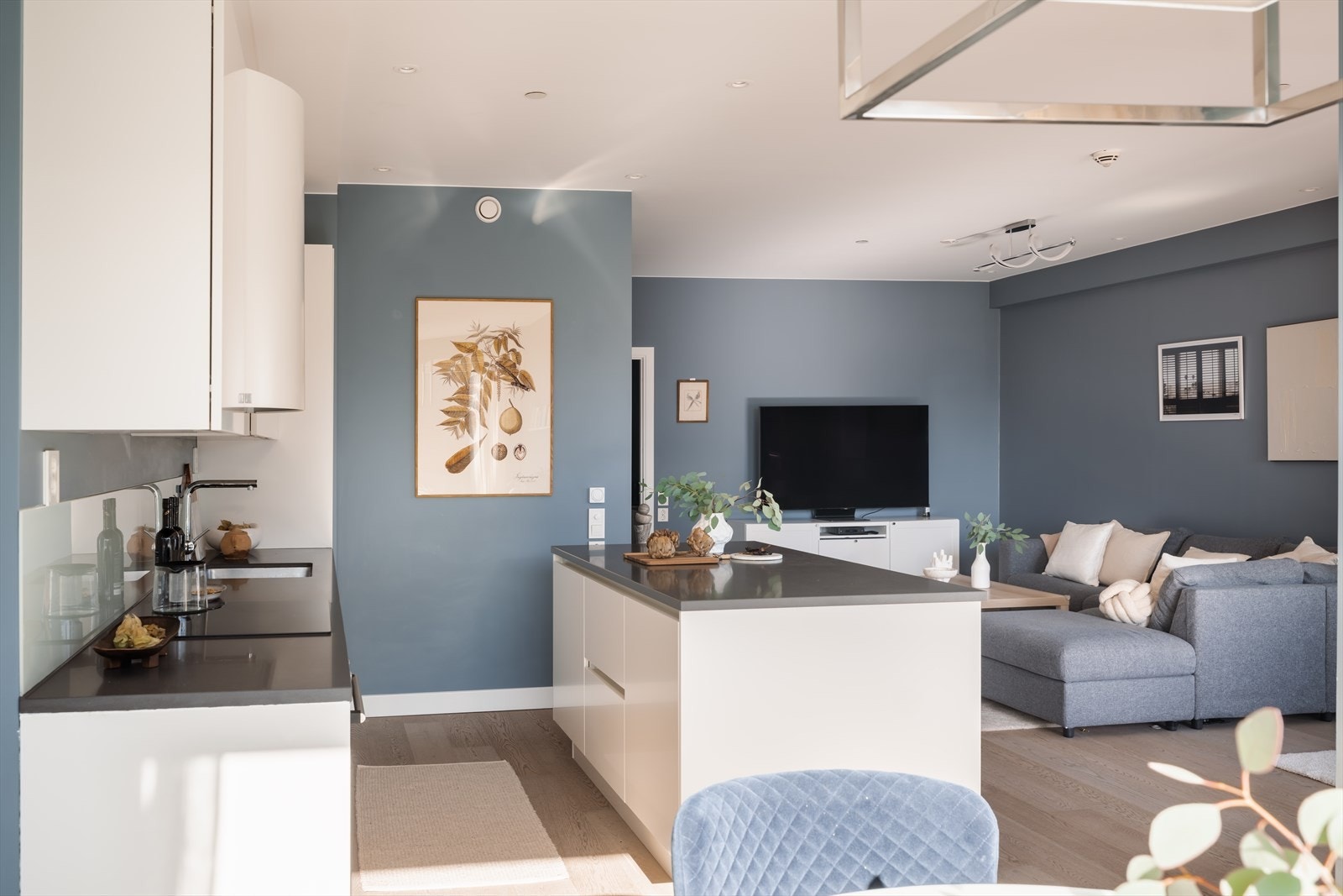 Over benkeplaten er det montert stilrene glassplater som både beskytter veggene og gir et moderne uttrykk. Arbeidsbelysning er ivaretatt med LED-lyslist under overskap, noe som gir gode lysforhold på kjøkkenbenken. Galleribilde