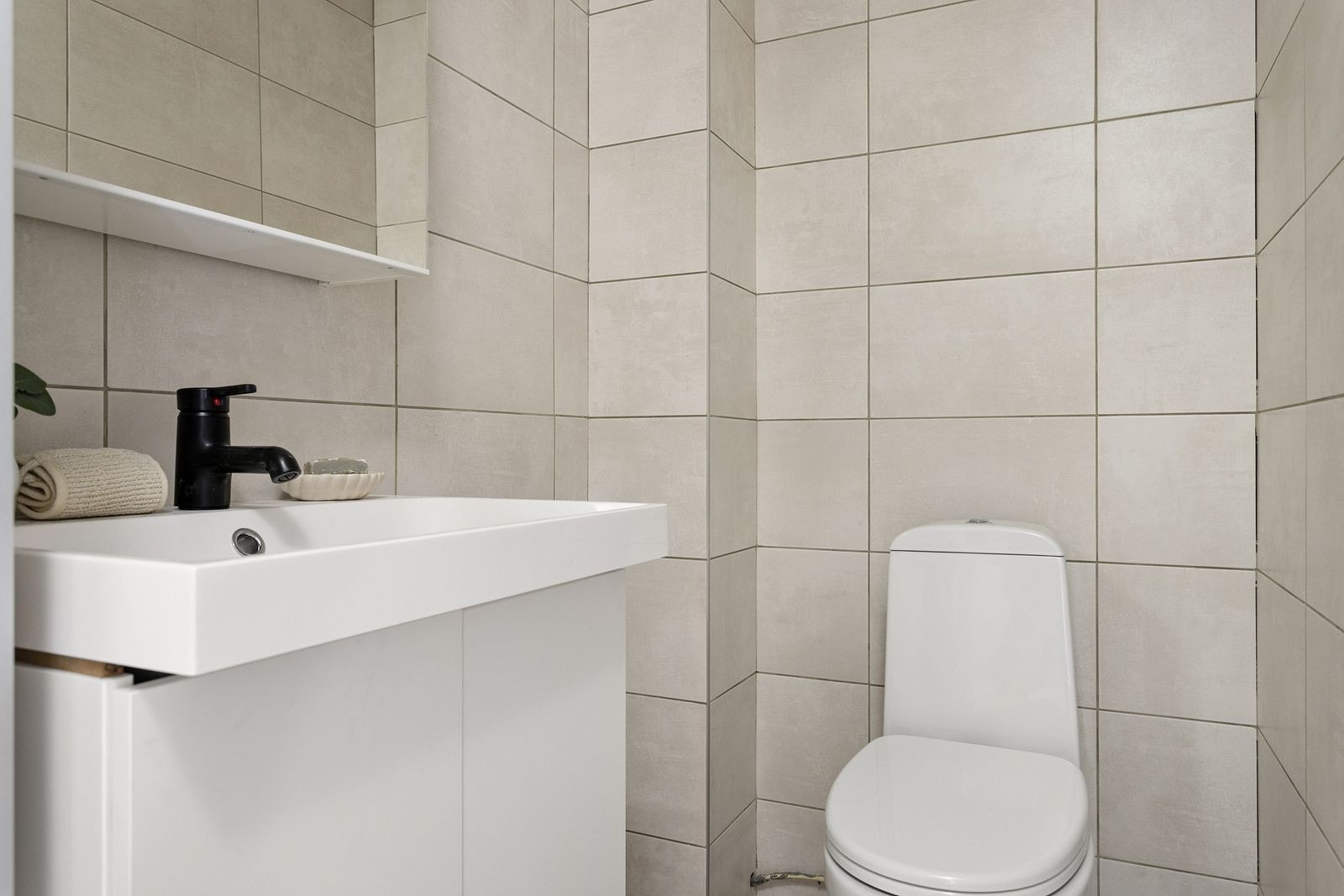 Baderom med dusjnisje, servant med underskap og toalett. Galleribilde