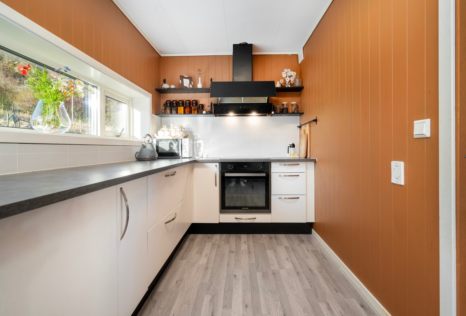 Kjøkkeninnredning med hvite fronter og aminat benkeplate. Galleribilde