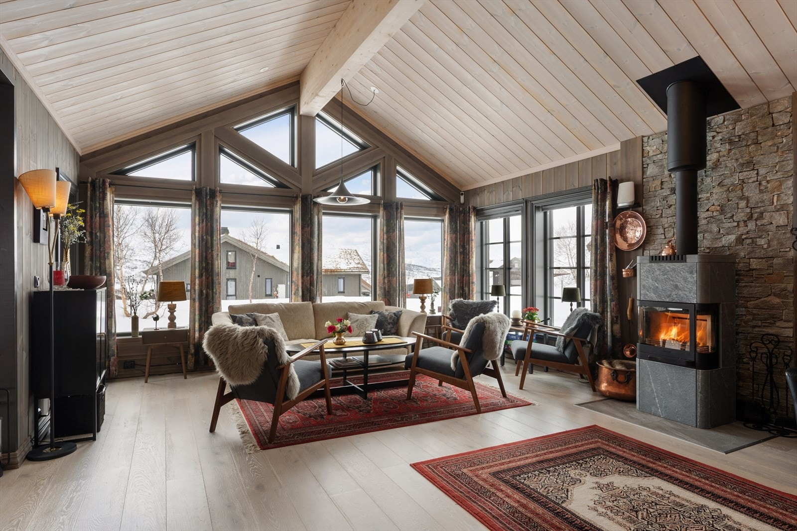 Stuen er lys og romslig, med generøs takhøyde og store vindusflater som skaper en luftig atmosfære. Galleribilde