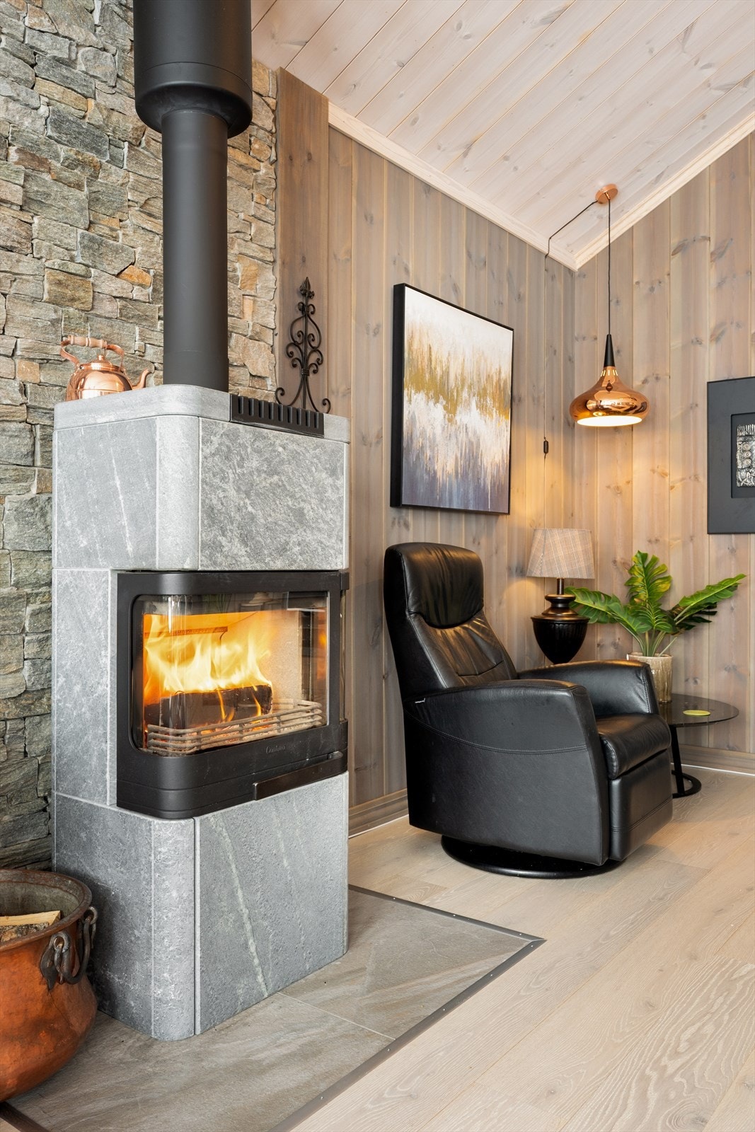 Peisovnen er plassert foran en solid steinvegg som gir et rustikt preg. Galleribilde