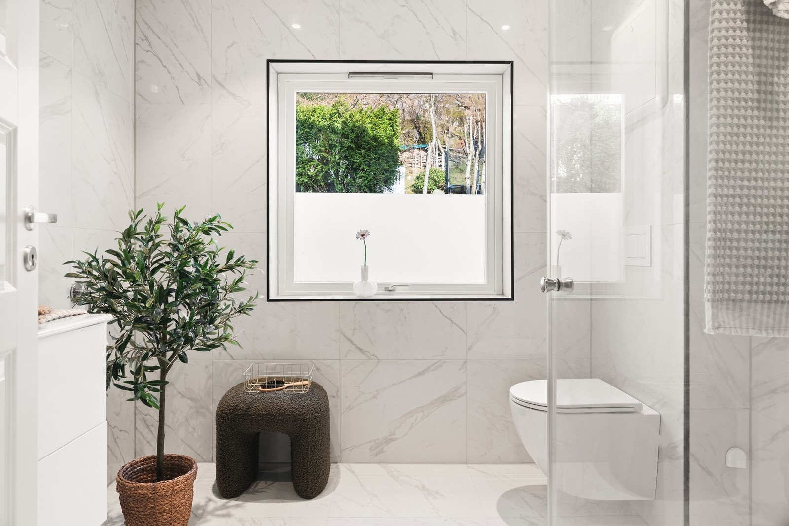 Badet inneholder dusjhjørne, vegghengt toalett og servant med møblement. Galleribilde