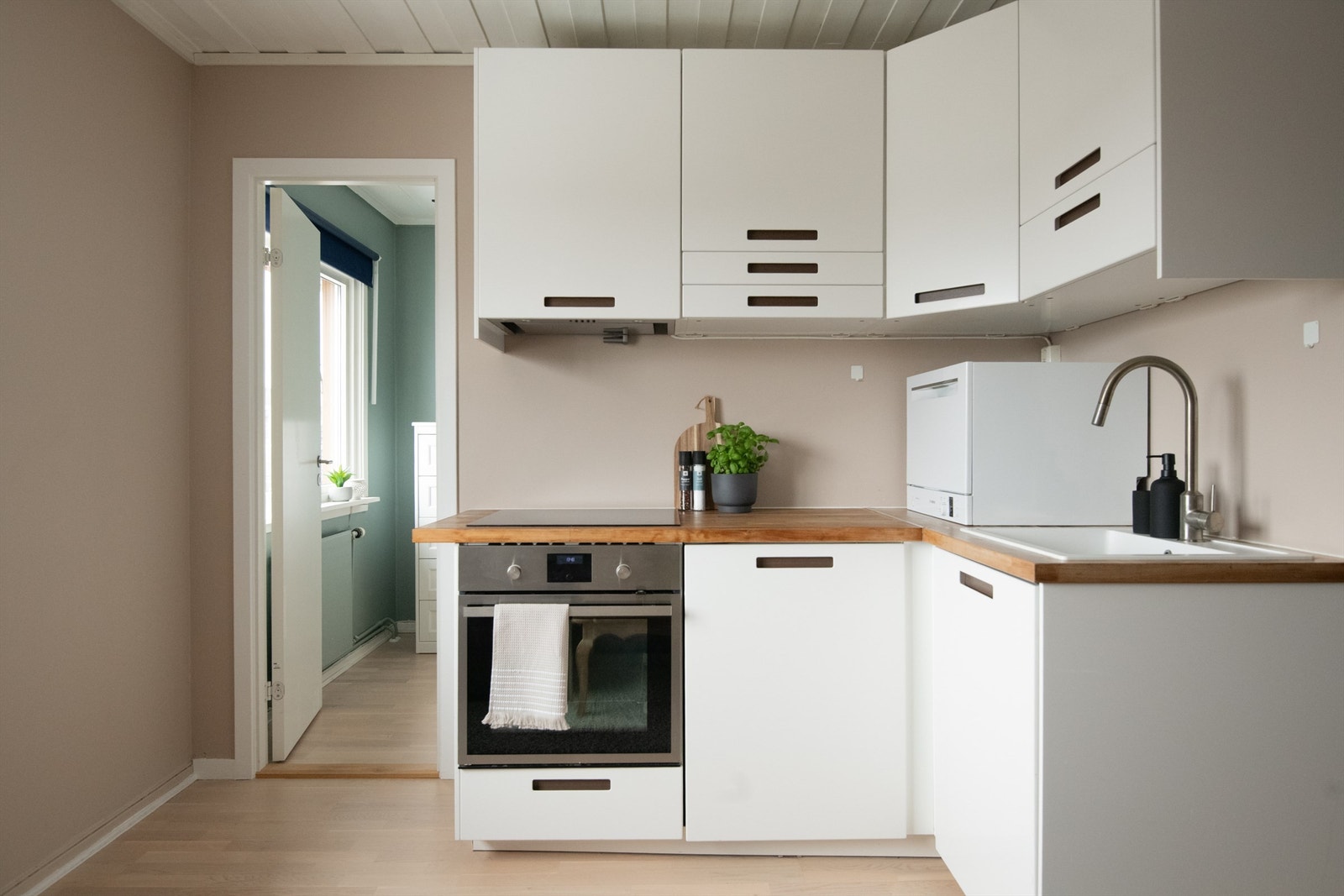 Kjøkkenet er utstyrt med integrerte hvitevarer som kjøleskap, komfyr og koketopp. En ventilator med kullfilter er montert i overskapet. Galleribilde