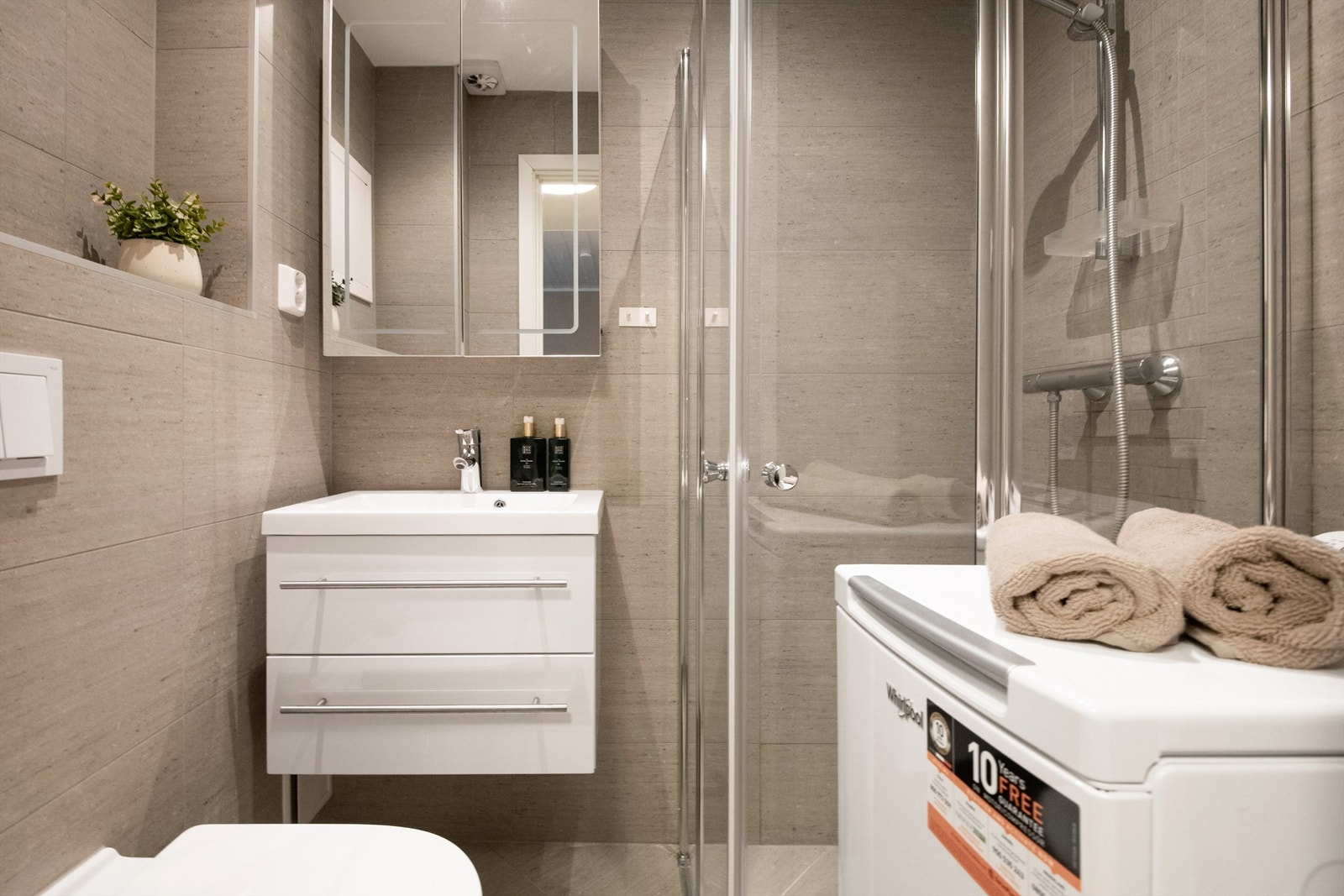 Badet ble renovert i 2020 og fremstår moderne og tidløst med lysegrå fliser. Her er det gulvvarme og downlights i taket. Galleribilde