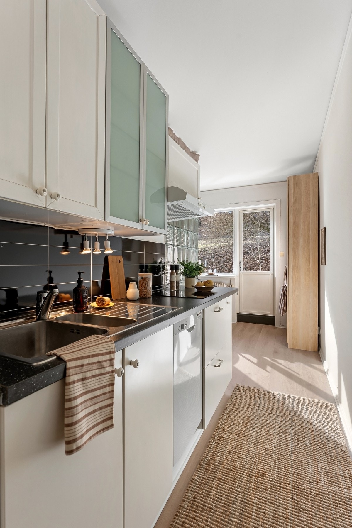 Innbydende og funksjonelt kjøkken med glatte fronter og enkelte vitrinefronter, som gir et moderne og hyggelig uttrykk Galleribilde