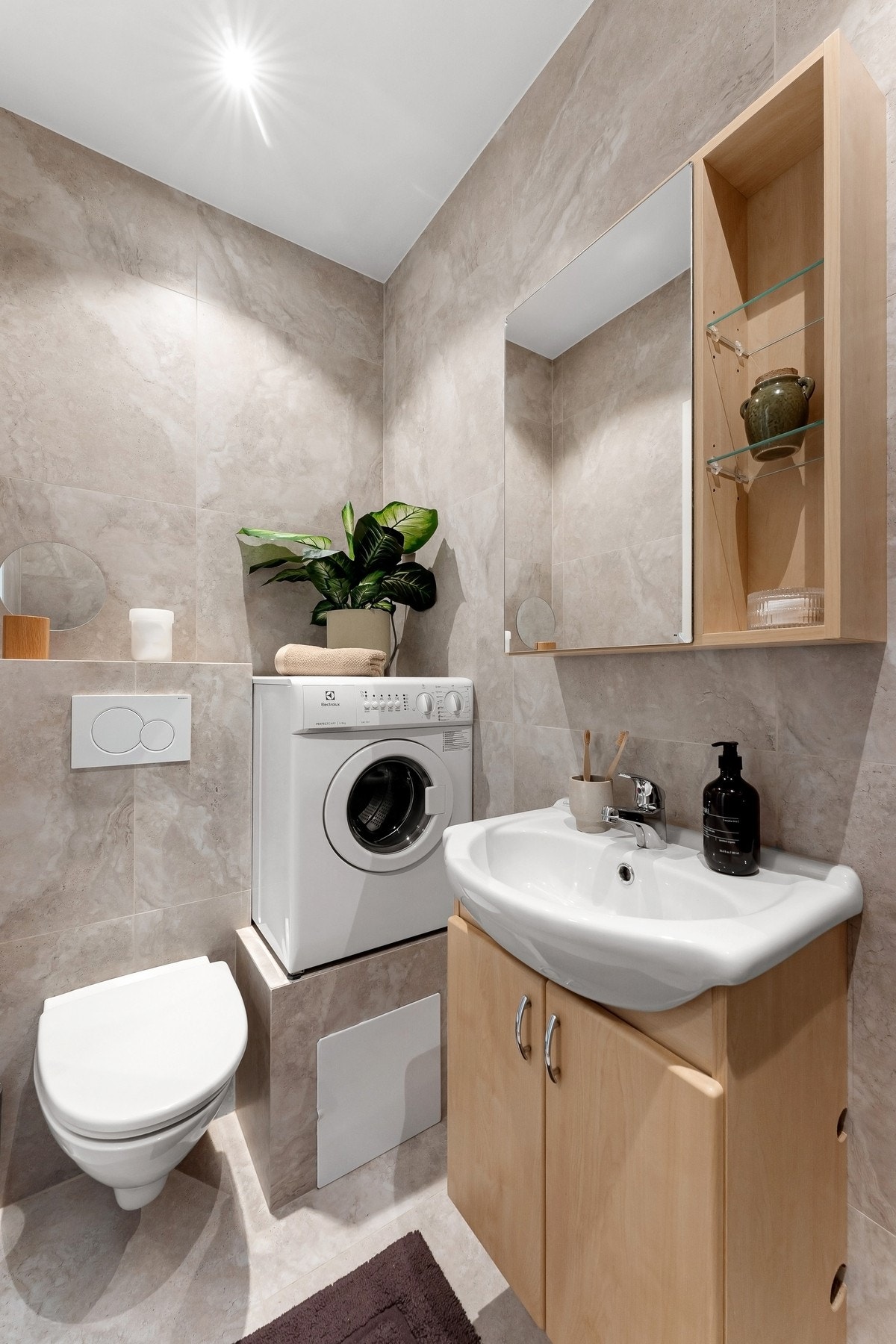 Oppbevaringsplass i servantskap med heldekkende servant og i speilskap på vegg. Veggmontert klosett og opplegg for vaskemaskin Galleribilde