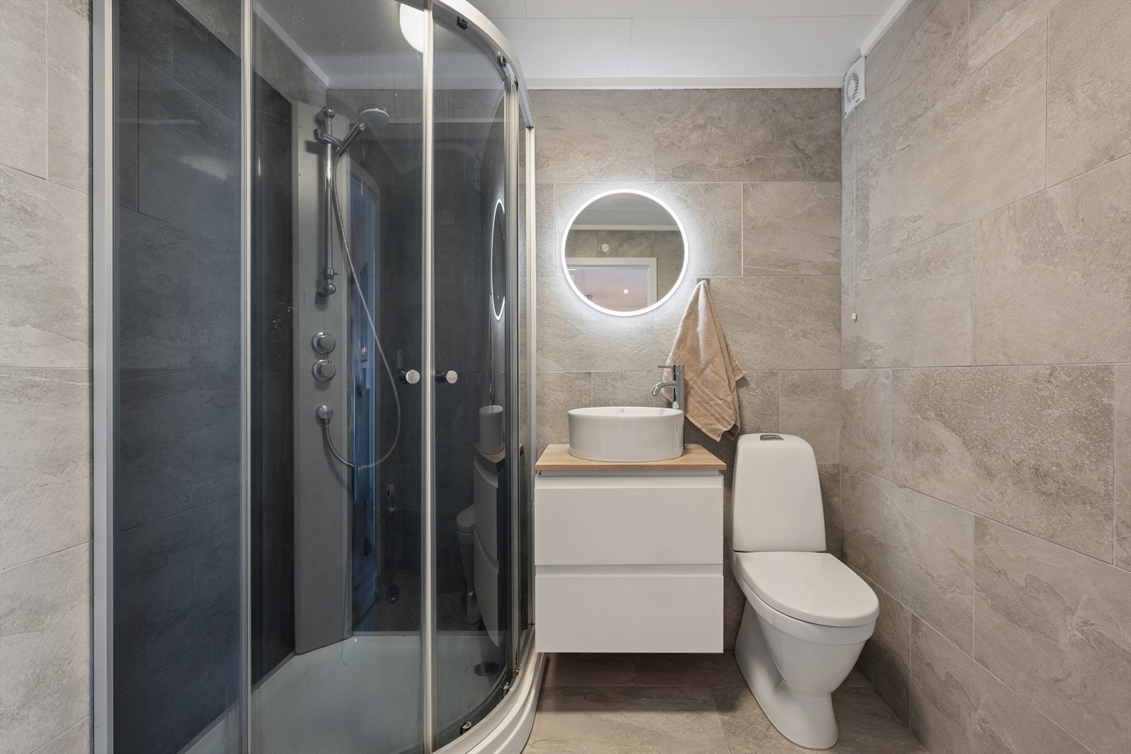 Dette lekre baderommet i soveromsetasjen (andre etasje) ble renovert i 2021 med lekkert flisevalg, gulvvarme, dusjkabinett, klosett og innredning Galleribilde