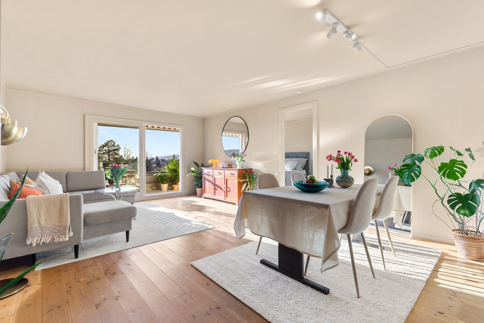 Romslig stue med store vinduer og utgang til balkong. Naturlig lysinnslipp skaper en lys og åpen atmosfære. Galleribilde