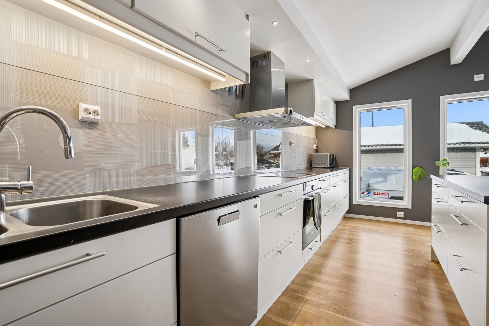 Lekkert og funksjonelt kjøkken med rene linjer, gode arbeidsflater og moderne integrerte hvitevarer. Galleribilde