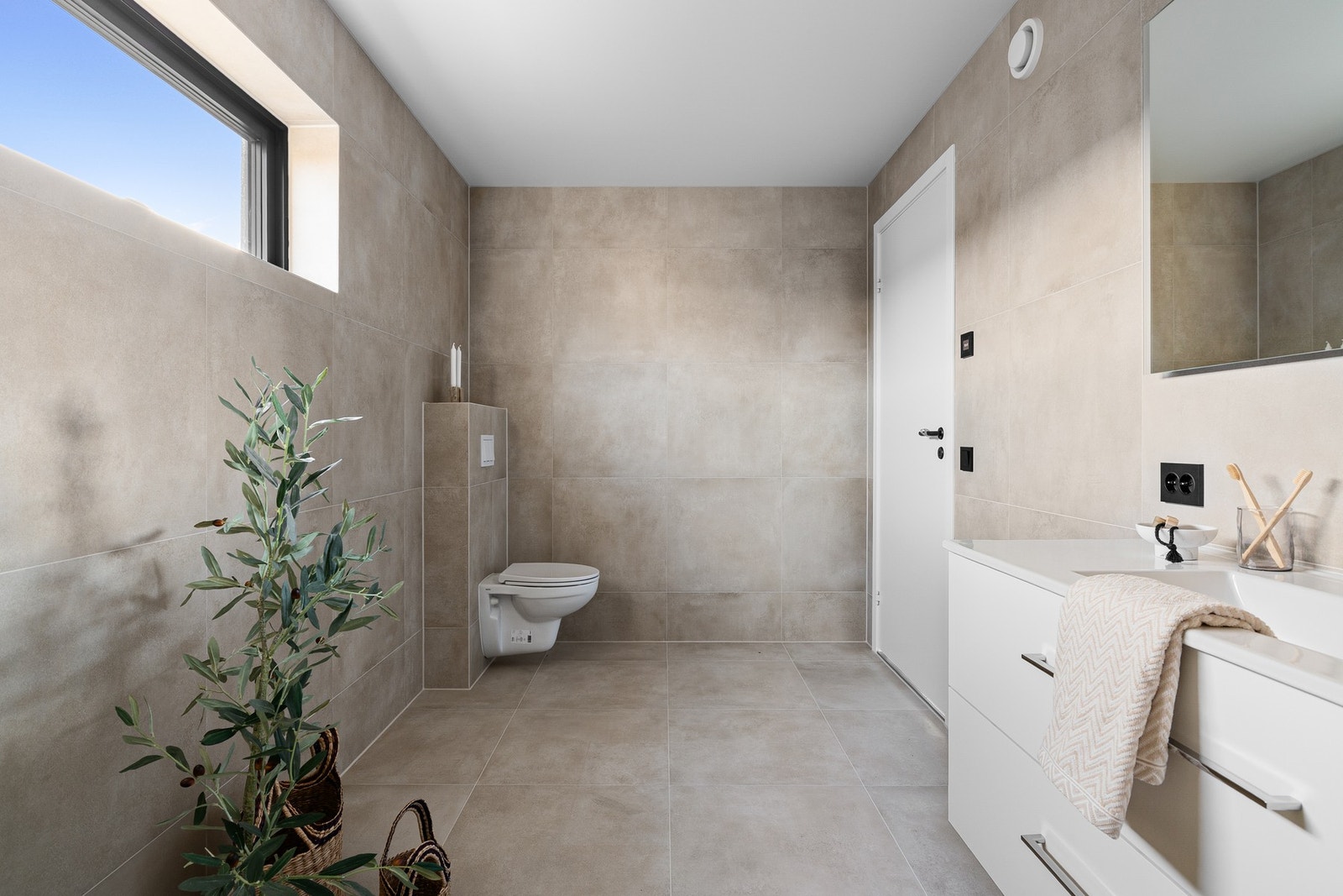 Innredningen består av en praktisk baderomsinnredning med nedfelt servant, vegghengt toalett og dusjhjørne. Galleribilde