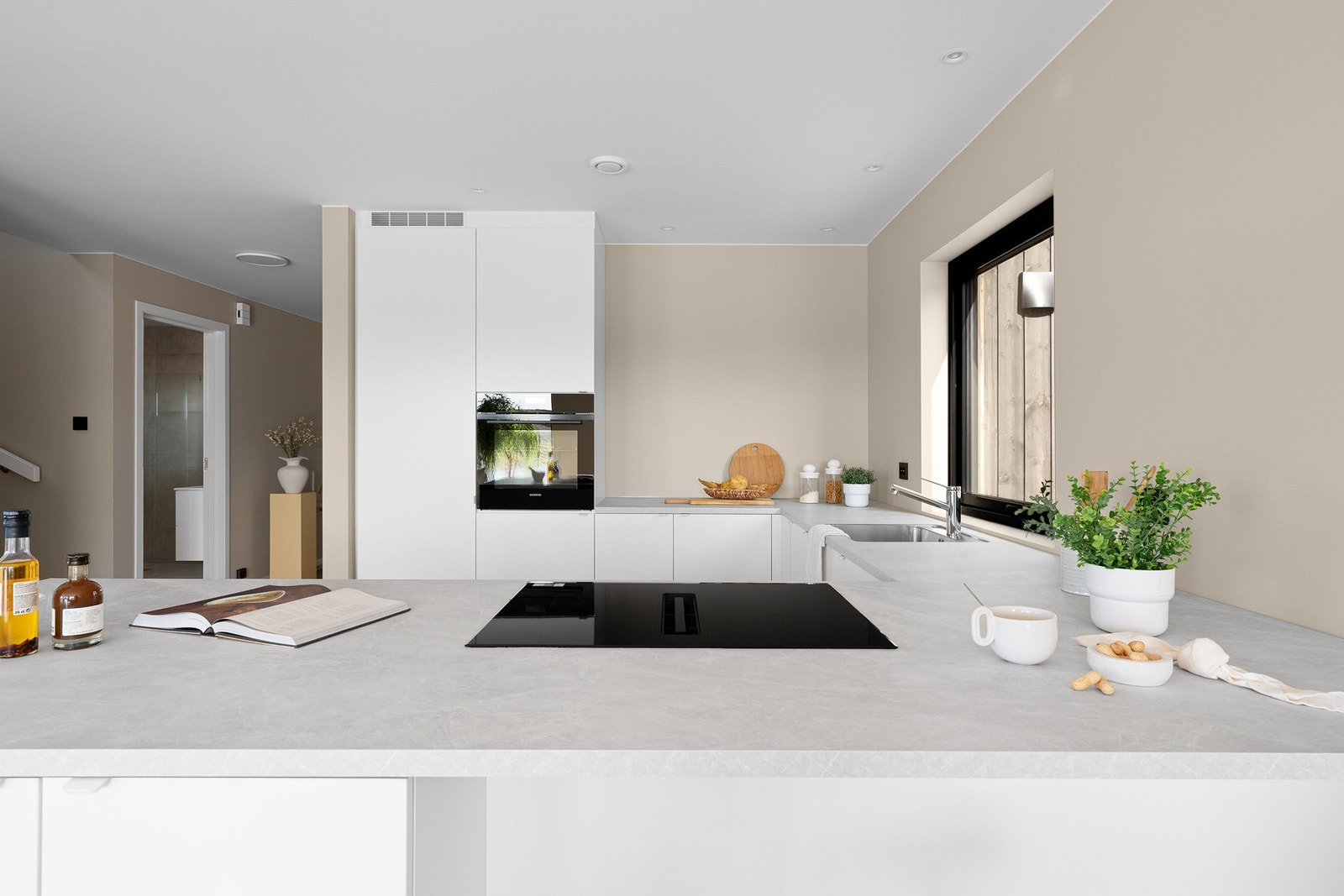 En barløsning med plass til barstoler gir en uformell spiseplass og gjør kjøkkenet til et naturlig samlingspunkt i boligen. Galleribilde