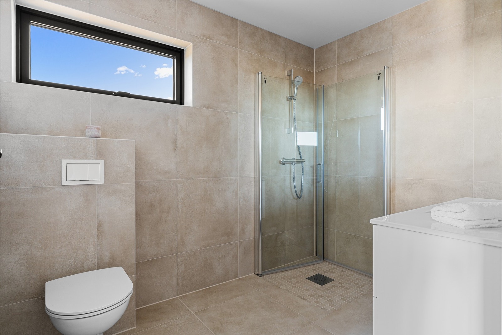 Rommet er utstyrt med servant, vegghengt toalett og dusjhjørne. Galleribilde