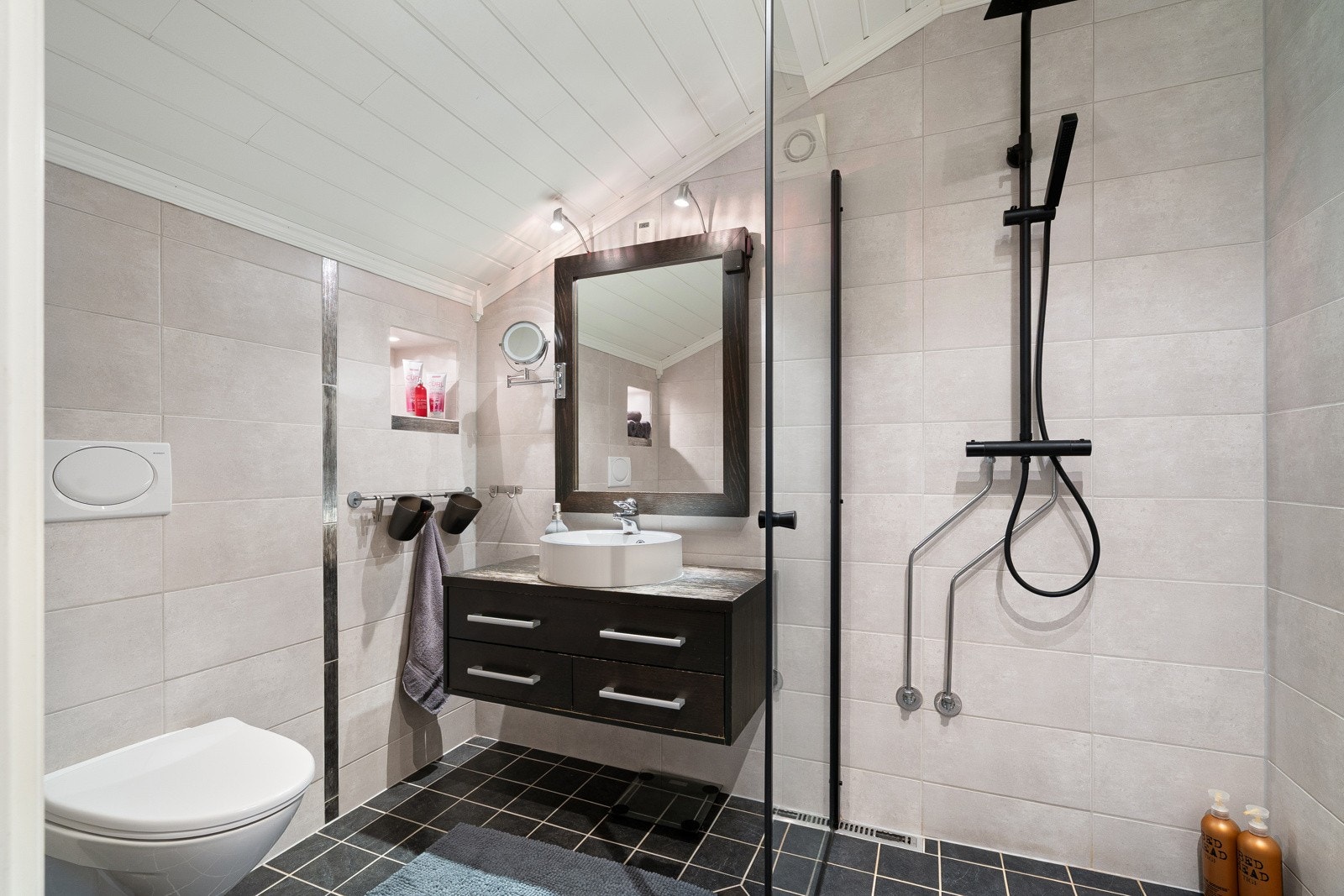 Badet er komplett med vegghengt toalett, innredning og dusj. Galleribilde