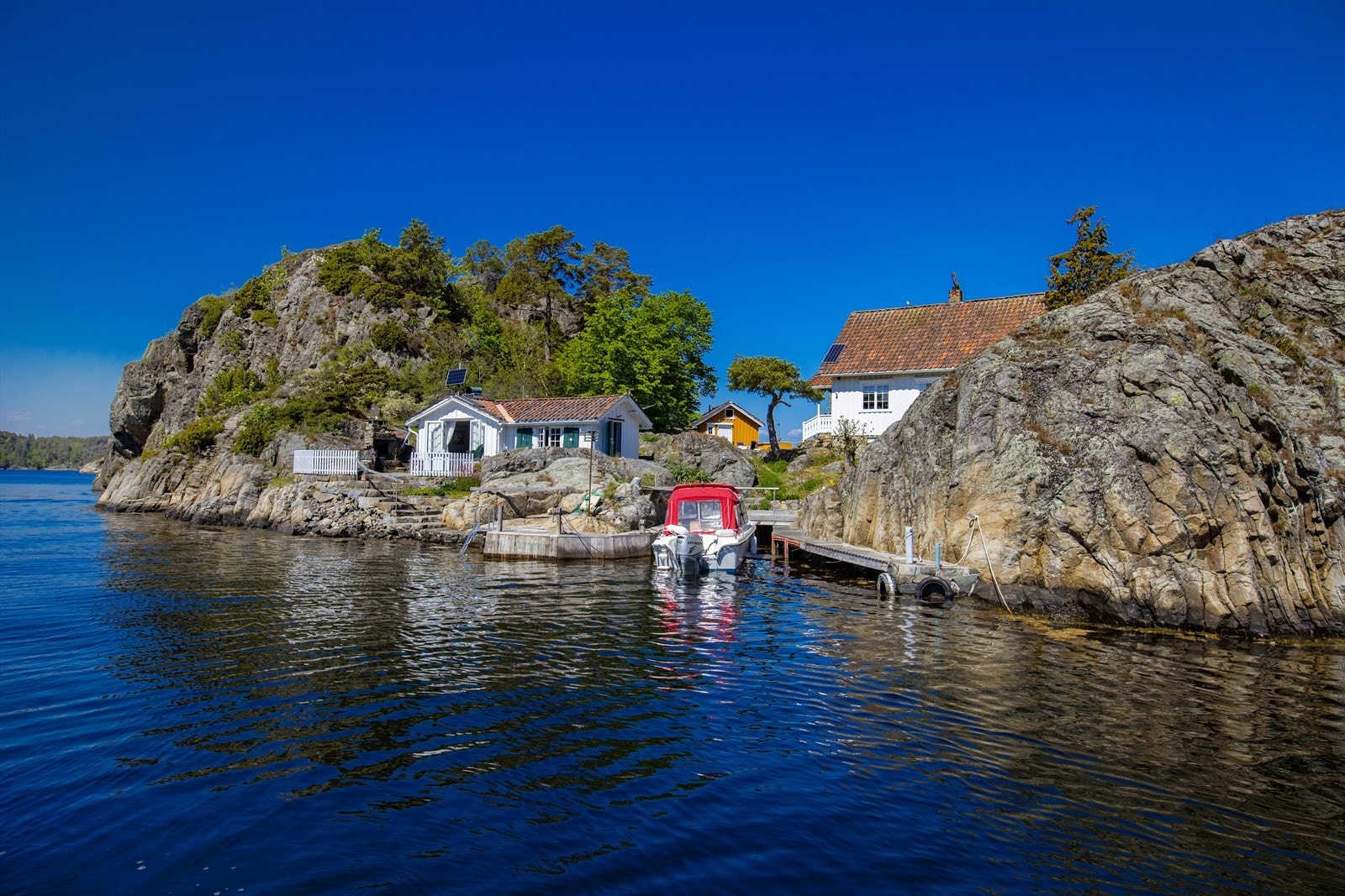 Fra annekset og uteplassen er det steintrapper ned til sjøen og brygge mot sør. Galleribilde
