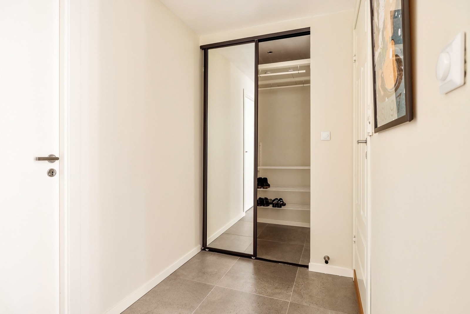 Entréen har nye fliser fra 2024 og en praktisk skyvedørsgarderobe med speilfronter for god oppbevaring. Galleribilde